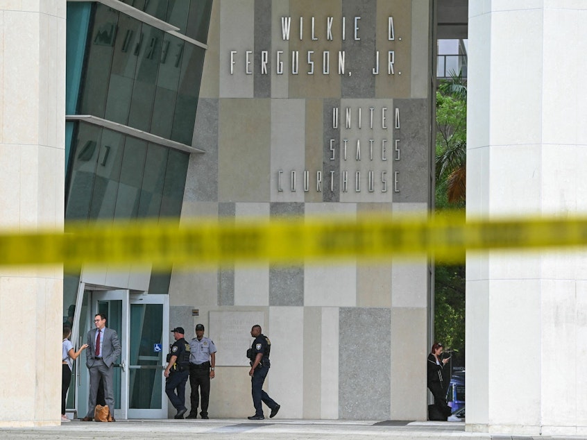 caption: People walk in front of the Wilkie D. Ferguson Jr. United States Federal Courthouse in Miami on Monday, the day before former President Donald Trump is expected to appear for an arraignment regarding 37 federal charges against him.