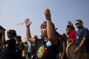 caption: Lummi tribal members dance and sing songs during a celebration of life for Tokitae on Sunday, August 27, 2023, at Jackson Beach Park on San Juan Island. 