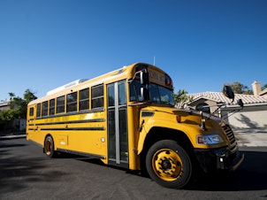 caption: A Clark County, Nev., School District school bus drives through a Summerlin neighborhood last month. The National School Boards Association included an incident from Clark County in its letter to President Biden.