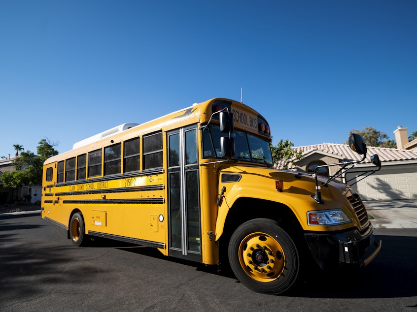 caption: A Clark County, Nev., School District school bus drives through a Summerlin neighborhood last month. The National School Boards Association included an incident from Clark County in its letter to President Biden.