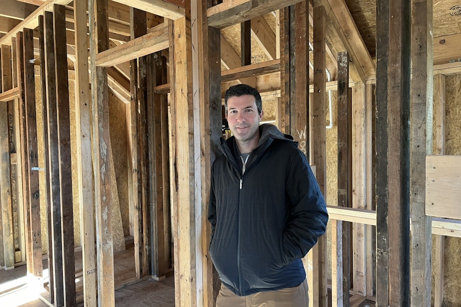 caption: Sean Conta of Targa Homes in a backyard cottage built using reclaimed lumber.