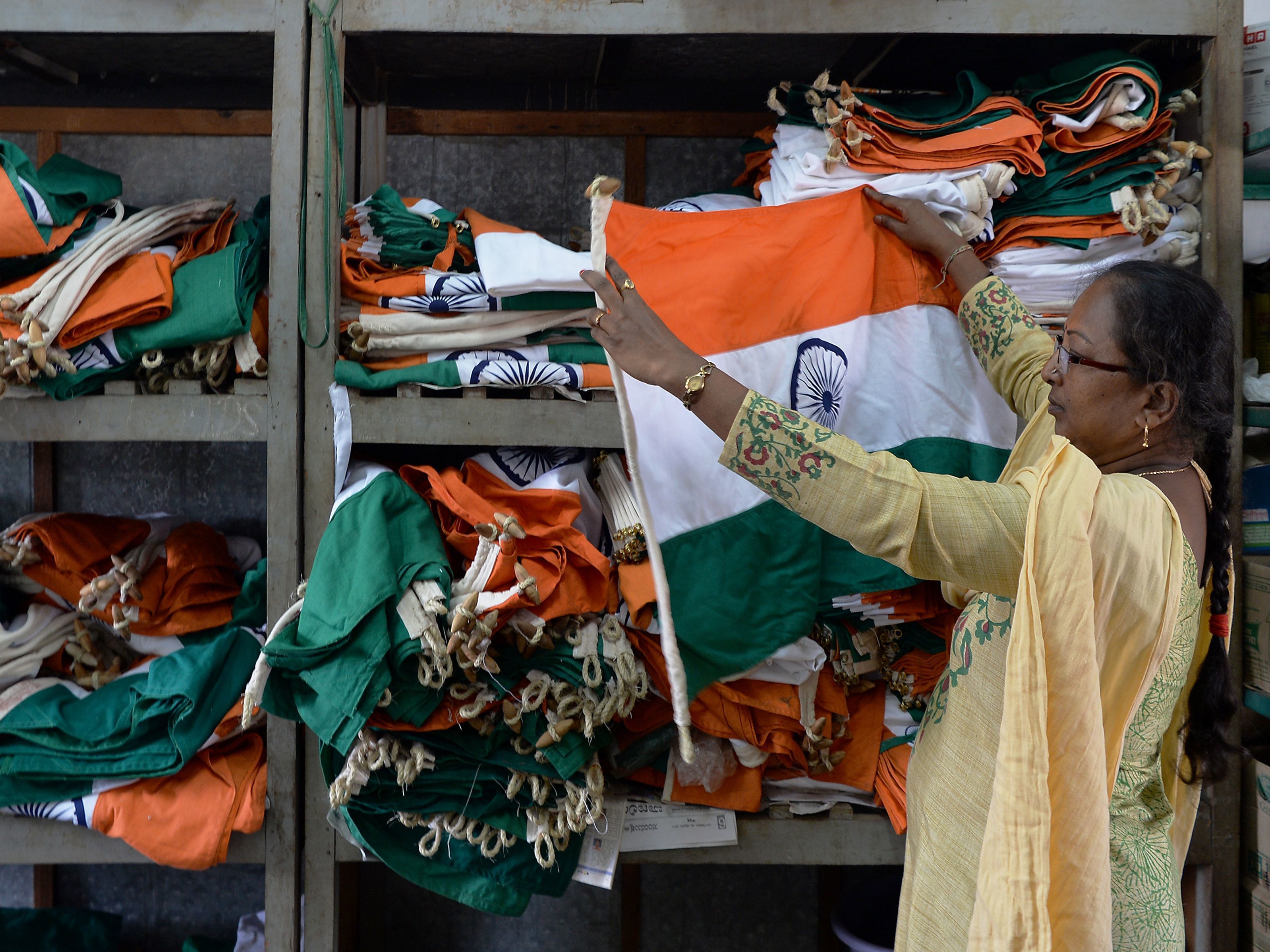 caption: An employee checking flags at the Indian National Flag Production Center in the southern state of Karnataka.