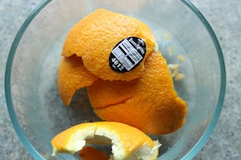caption: Does this orange peel belong in the trash, recycling or compost?