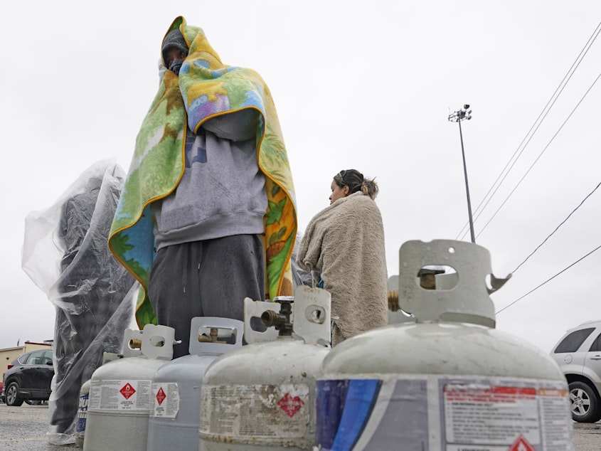 caption: Carlos Mandez is in line to fill his propane tanks on  Wednesday, in Houston. Customers had to wait over an hour in the freezing rain to fill their tanks as millions in Texas still had no power after a historic snowfall and single-digit temperatures created a surge of demand for electricity.