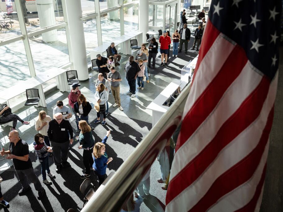 caption: Voters line up to cast their ballots at the Stamford Government Center on the first day of early voting on Oct. 21 in Stamford, Conn.