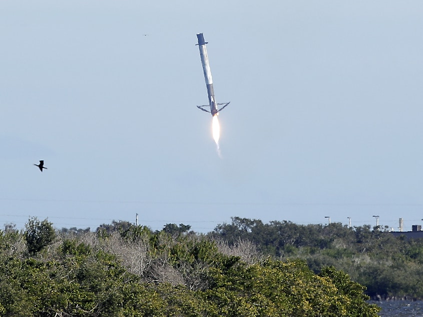 caption: Falcon 9 rocket first stage booster experiencing control problems and missing a landing zone at Cape Canaveral, Fla.