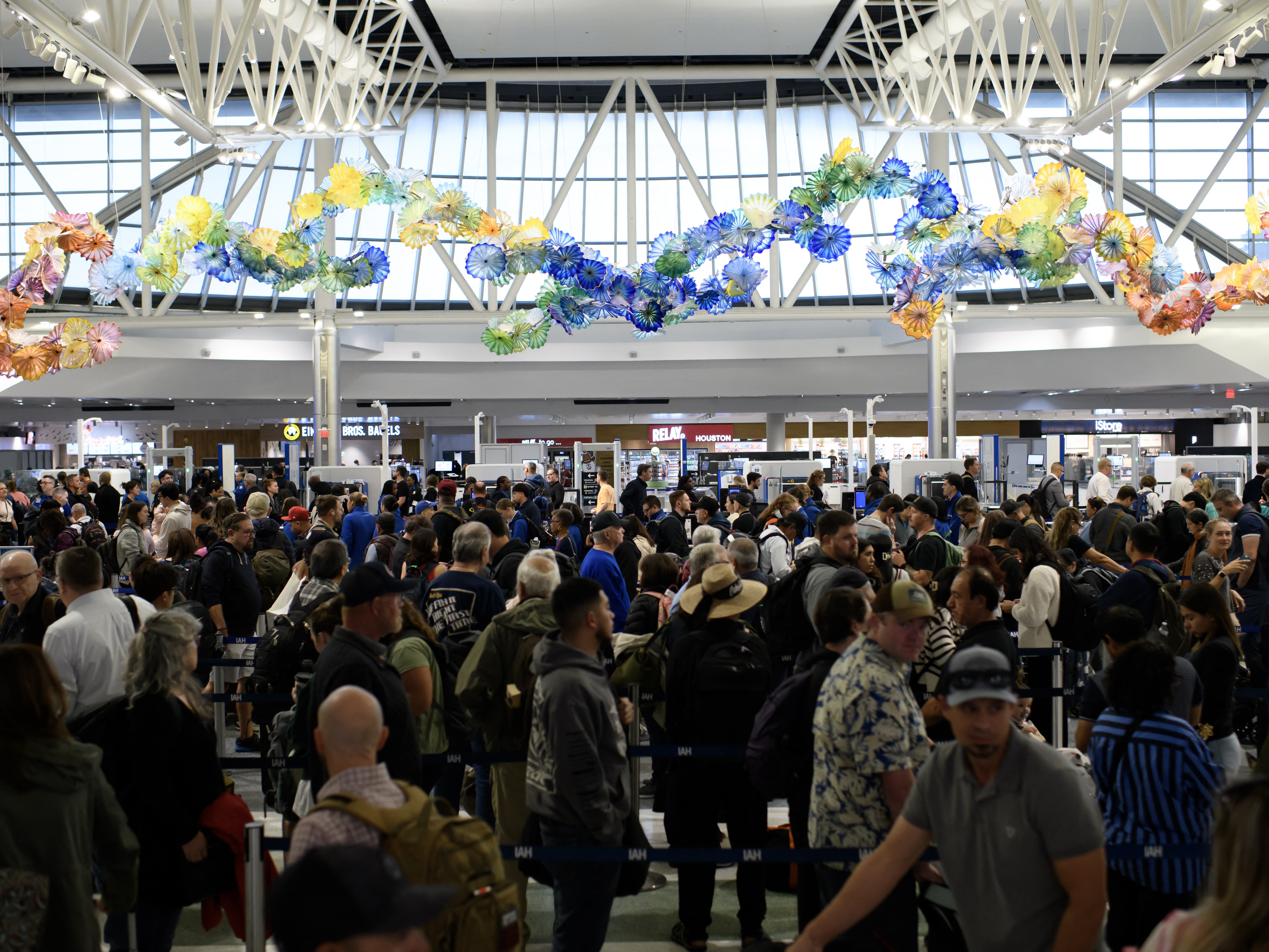 caption: People wait in a security checkpoint line at George Bush Intercontinental Airport in Houston on Nov. 4.