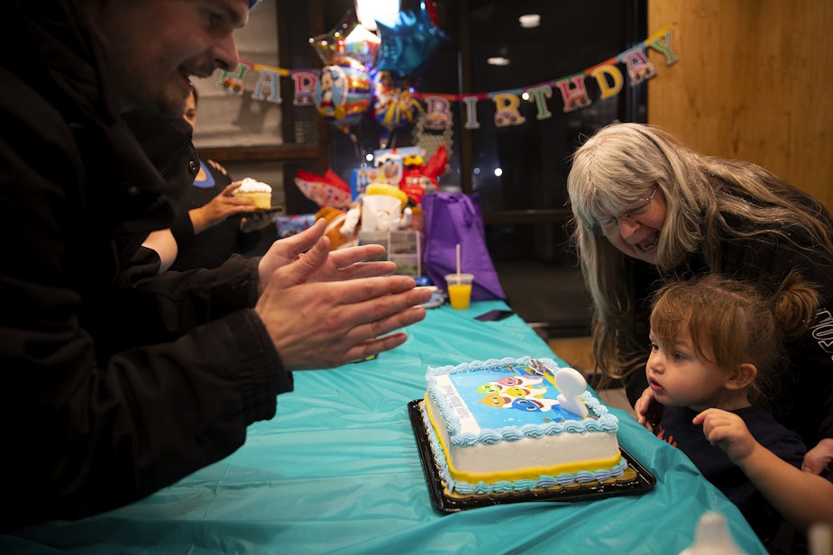 caption: Messiah, 2, blows out a candle during his second birthday party, with his father, Sean, left, and grandmother, Linda, right, on Friday, November 18, 2022, at a McDonald’s. 