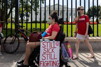 caption: Protesters march outside the White House to call attention to those who have long COVID.