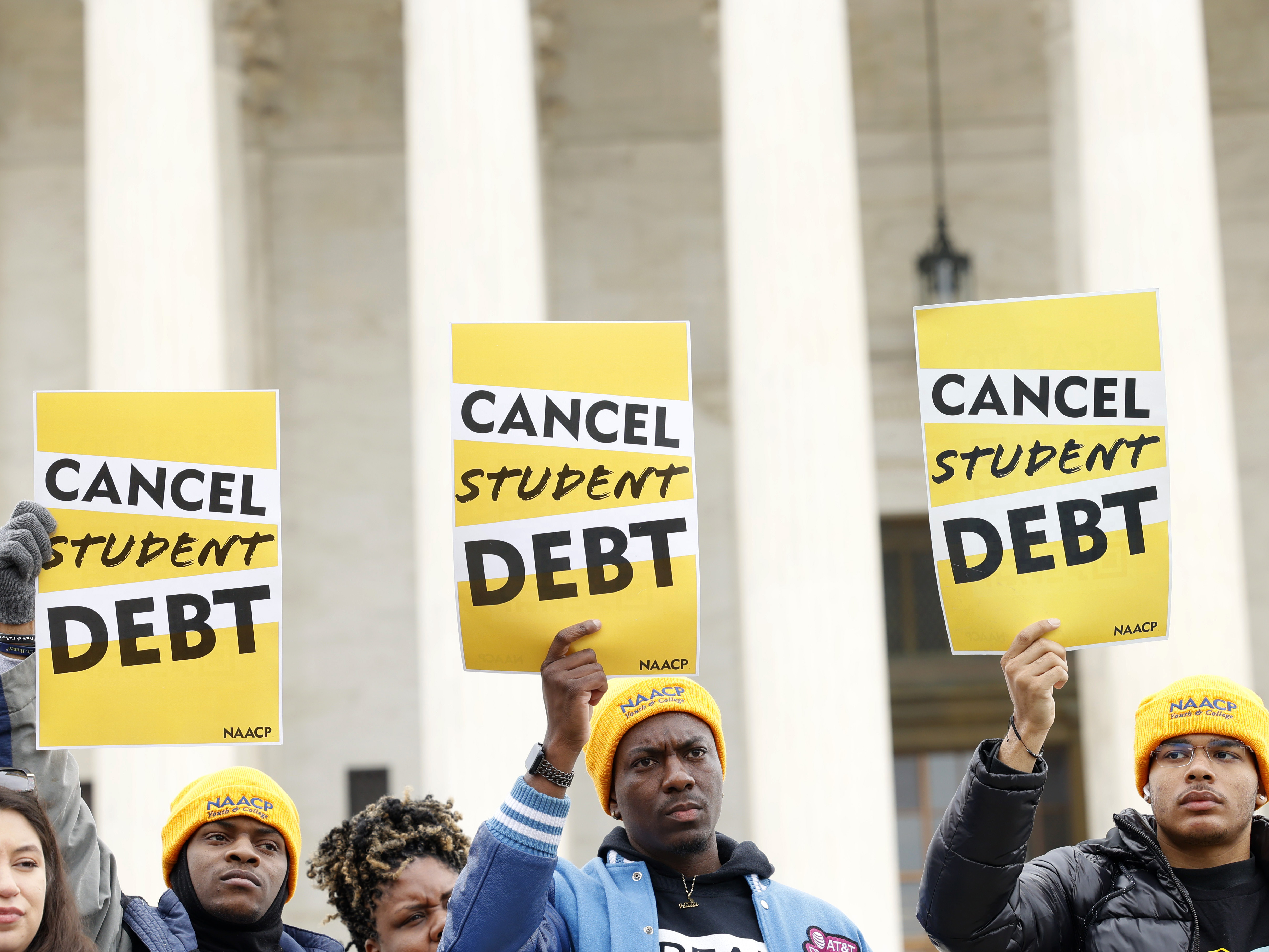 caption: Student loan borrowers gather outside the Supreme Court building in February 2023. The court's ruling on President Biden's debt relief plan is expected in June or July.