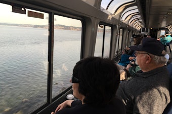 caption: Passengers on Amtrak's Coast Starlight watch Puget Sound roll by