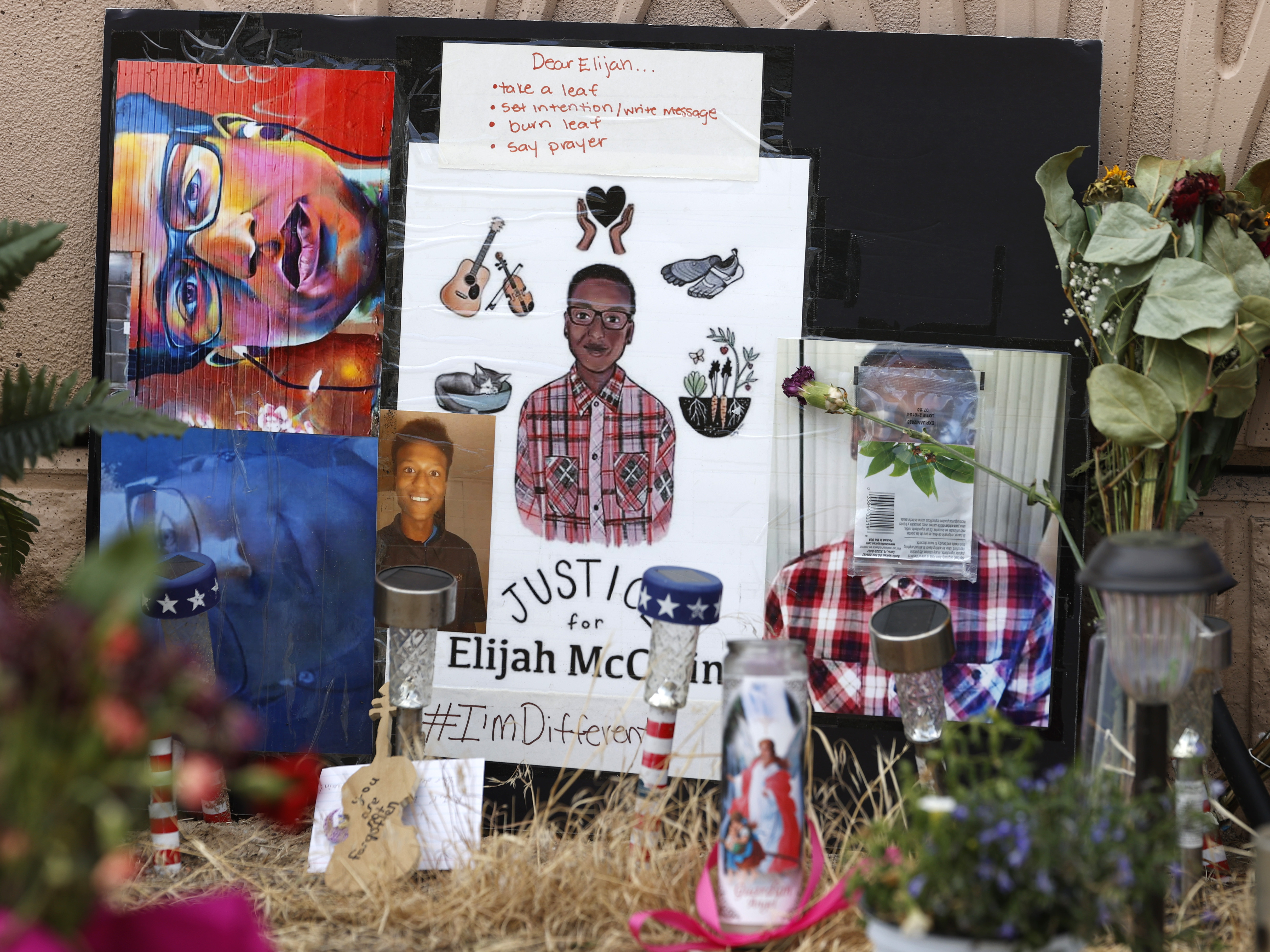 caption: In this July 3, 2020, file photo, a makeshift memorial stands at a site across the street from where Elijah McClain was stopped by police officers while walking home in Aurora, Colo.