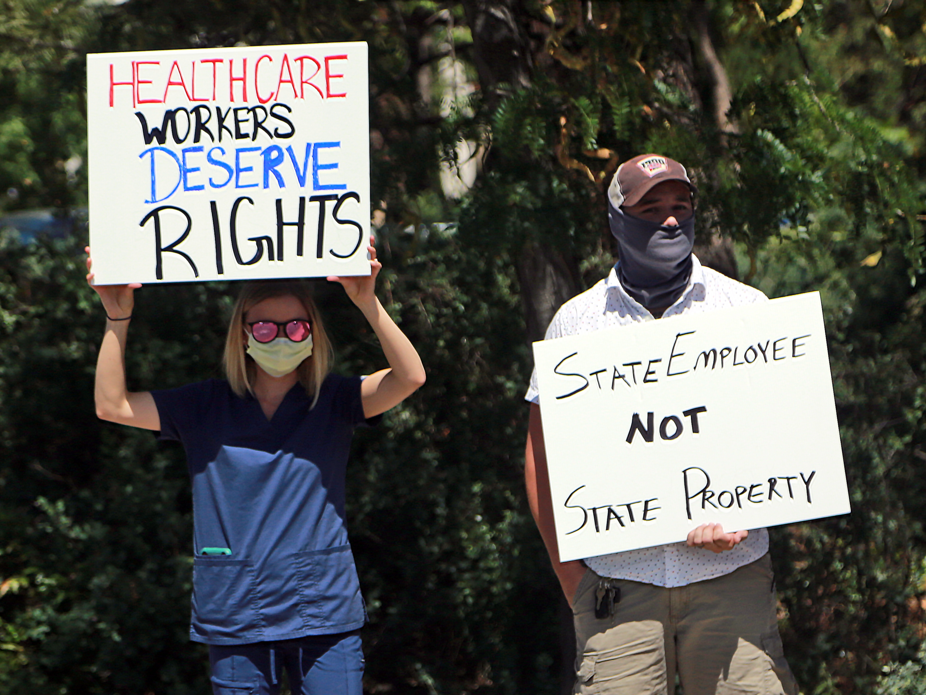 caption: Nurse Katrina Philpot (left) protests against COVID-19 vaccine and mask mandates in Santa Fe, N.M., in August.
