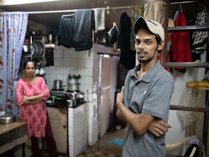 caption: Salman Khan Rashid, 24, right, and his mother, Sana Rashid, at home. Salman lost his job as a golf coach at a Mumbai sports club during the pandemic. The household, which includes Salman's three sisters, is now surviving on savings. But when he's able, he'll give a little money or food to others facing food insecurity.