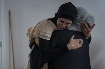 caption: García greets a woman before Friday prayer.
