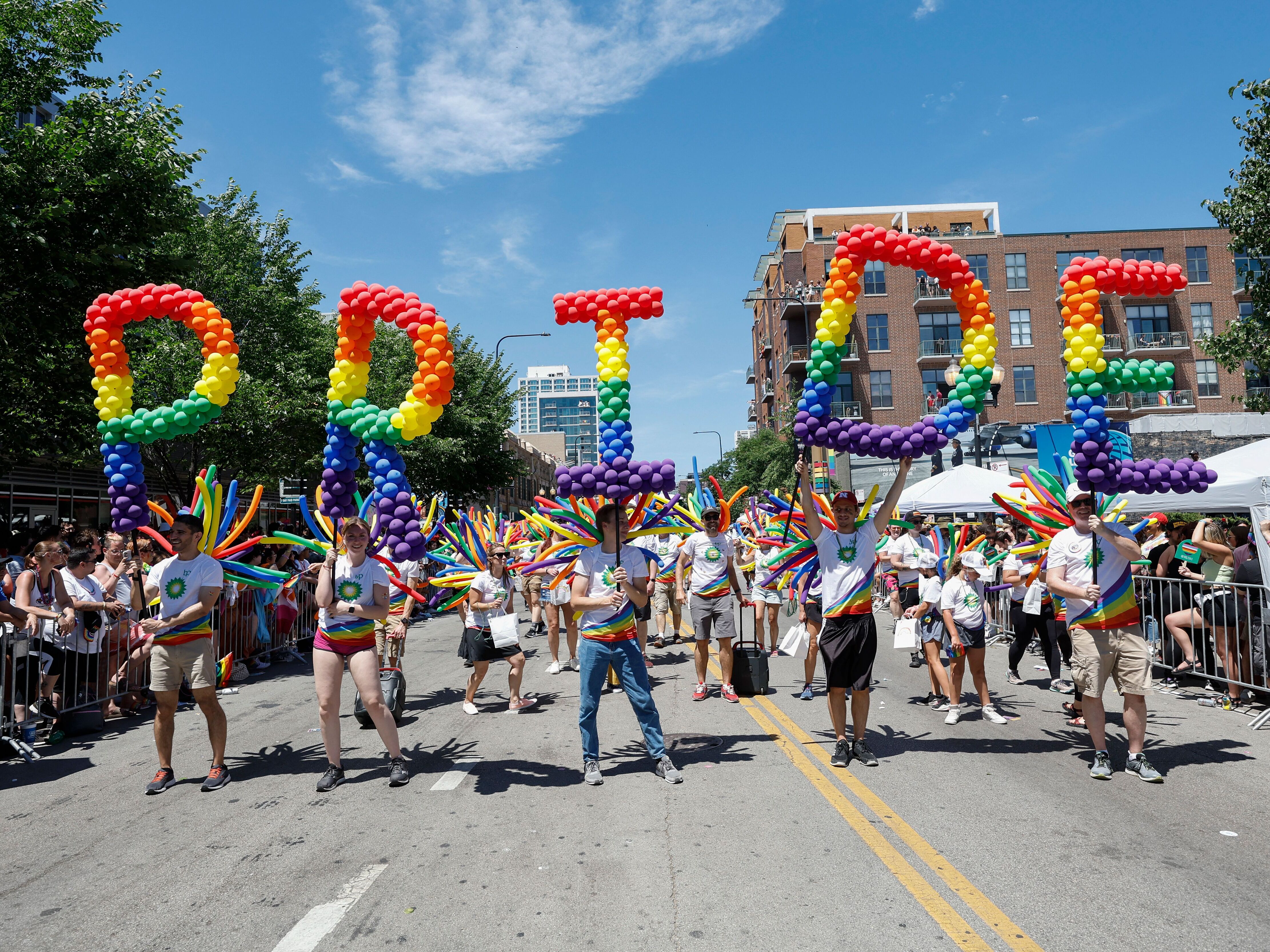 caption: Participants carry balloons spelling out "Pride" during the 51st LGBTQ Pride Parade in Chicago on June 26, 2022.
