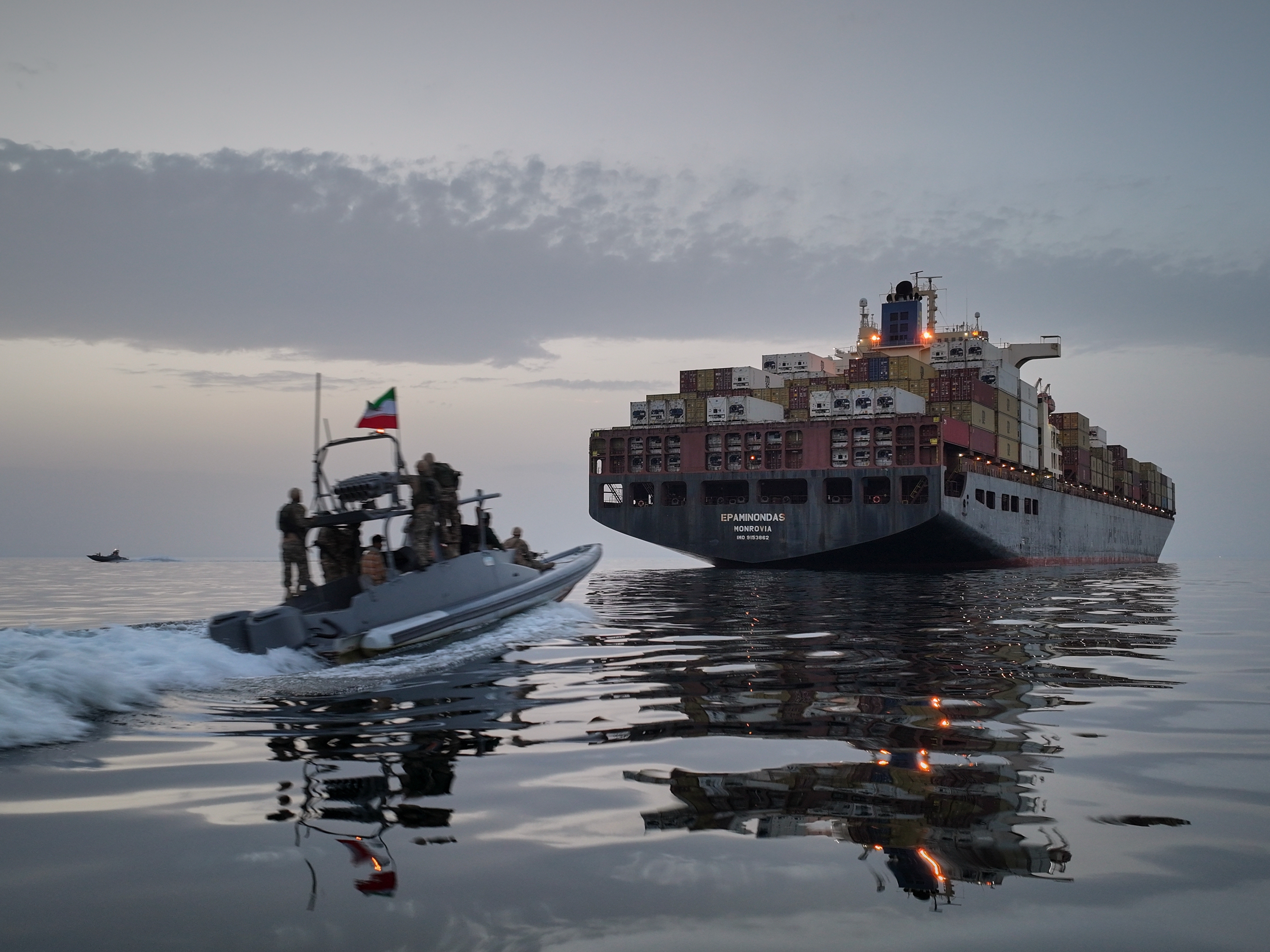 caption: A Revolutionary Guard Navy (IRGC) speedboat approaches the cargo ship Epaminondas during what state media described as the seizure of one of two vessels accused of violations in the Strait of Hormuz, April 21, 2026.