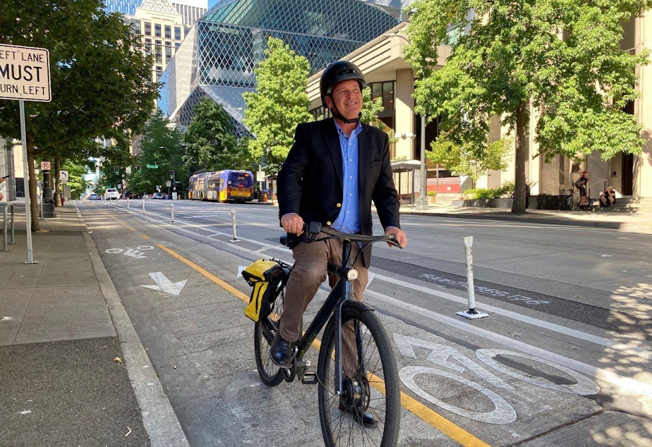 caption: Greg Spotts, the new director of the Seattle Department of Transportation prepares to bike along the protected bike lane on 4th Avenue in downtown Seattle. 