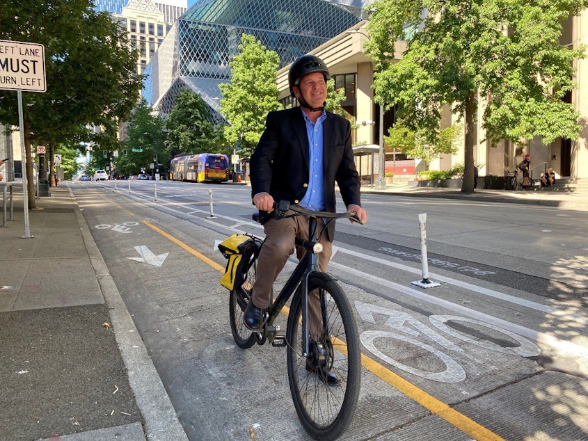 caption: Greg Spotts, the new director of the Seattle Department of Transportation prepares to bike along the protected bike lane on 4th Avenue in downtown Seattle. 