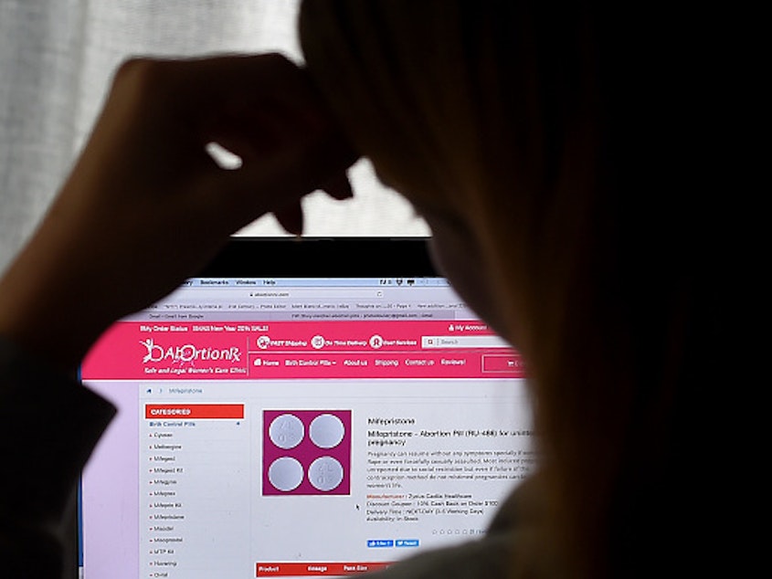 caption: In this photo illustration, a person looks at an Abortion Pill (RU-486) for unintended pregnancy from Mifepristone displayed on a computer on May 8 in Arlington, Va.