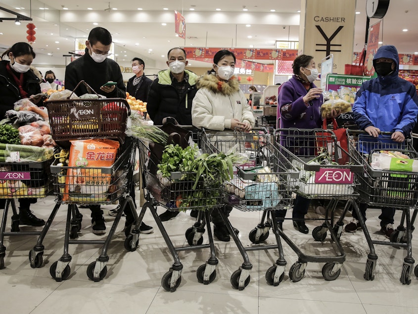 caption: On Jan. 23, 2020, as the coronavirus spread in China, residents of Wuhan, where it was first identified, donned masks to go shopping. The U.S. didn't officially endorse masks as a preventive measure for the public for a number of weeks.