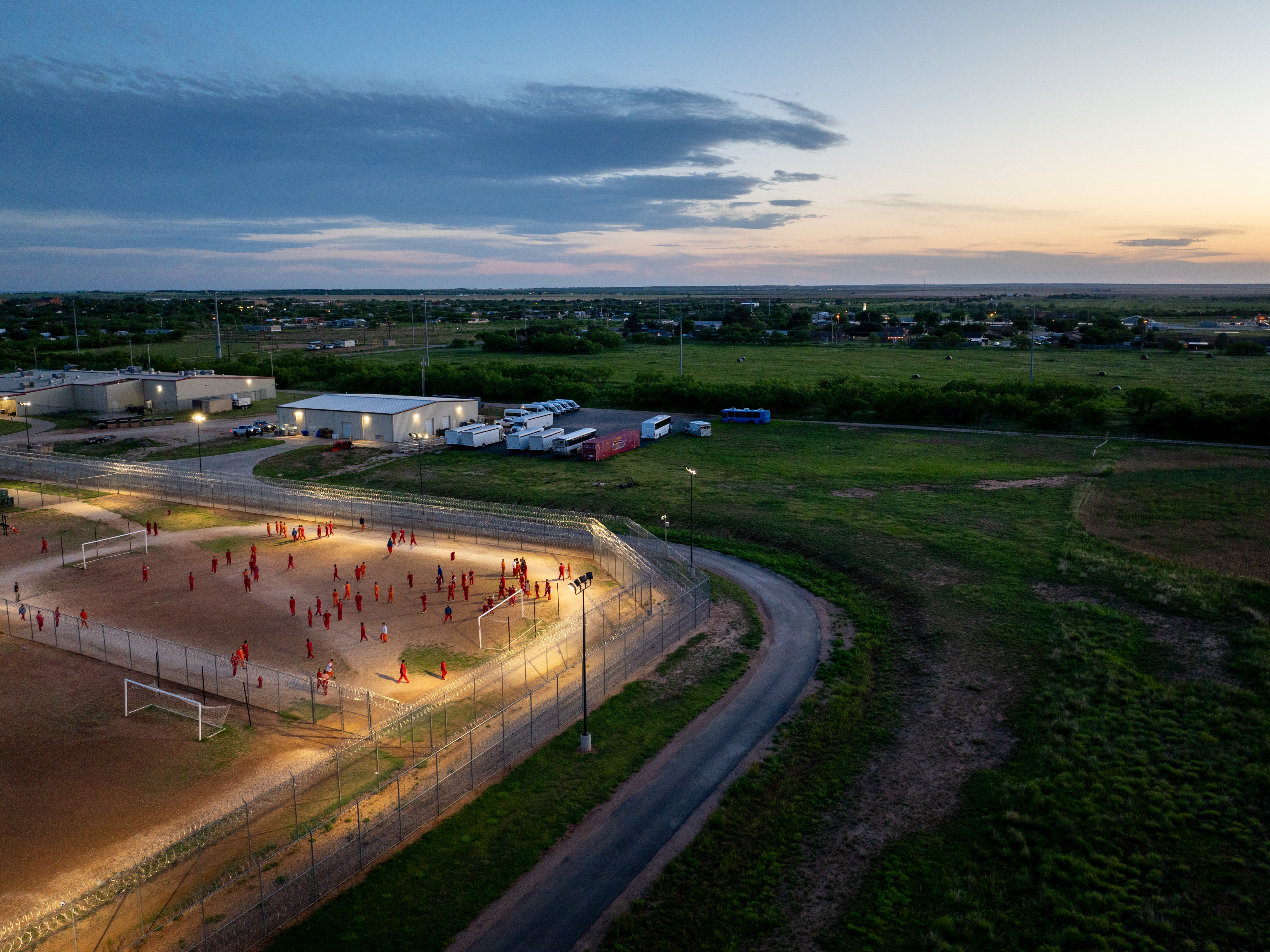 caption: In an aerial view, inmates are seen in the courtyard at the Bluebonnet Detention Center on May 12 in Anson, Texas. ICE has begun transferring illegal immigrant detainees to the Bluebonnet Detention Center after U.S. District Judge Wesley Hendrix readily offered the facility to the Trump administration under the Alien Enemies Act.
