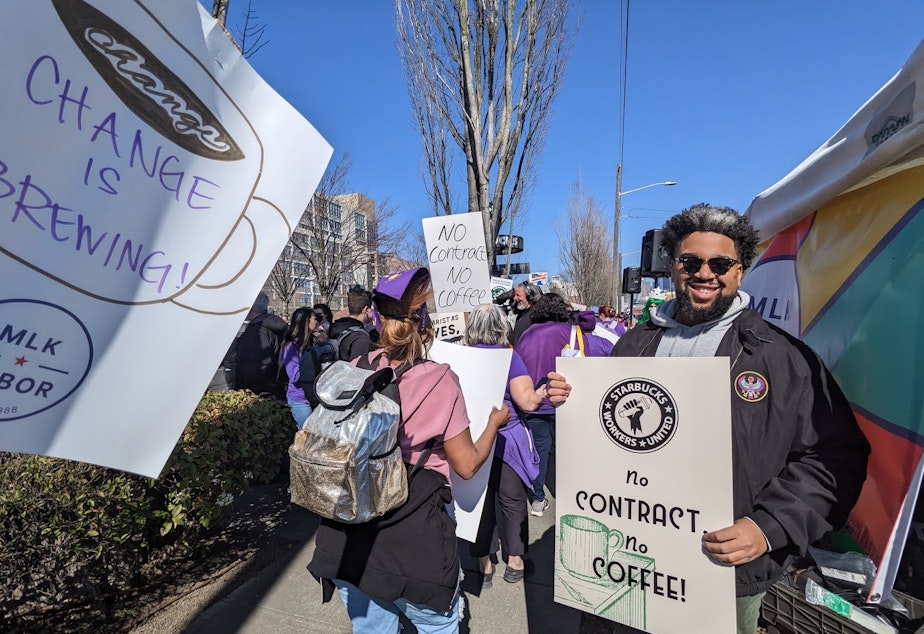 caption: Brandon Hersey pauses to be photographed during a picket Wednesday, March 22, 2023, outside Starbucks' Seattle headquarters.