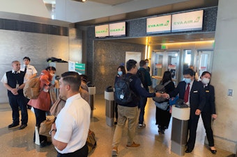 caption: Humans — workers and flight crews as well as passengers — can be exposed to any number of pathogens at airports. EVA Air employees are seen wearing face masks at the Los Angeles airport in February amid the coronavirus outbreak. U.S. officials advise masks are not the best way to mitigate one's risk of contracting the virus.