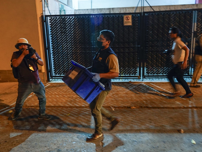 caption: An agent from the attorney general's office carries evidence collected at Save the Children's headquarters during a raid in Guatemala City on Thursday, April 25, 2024.