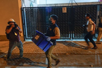 caption: An agent from the attorney general's office carries evidence collected at Save the Children's headquarters during a raid in Guatemala City on Thursday, April 25, 2024.