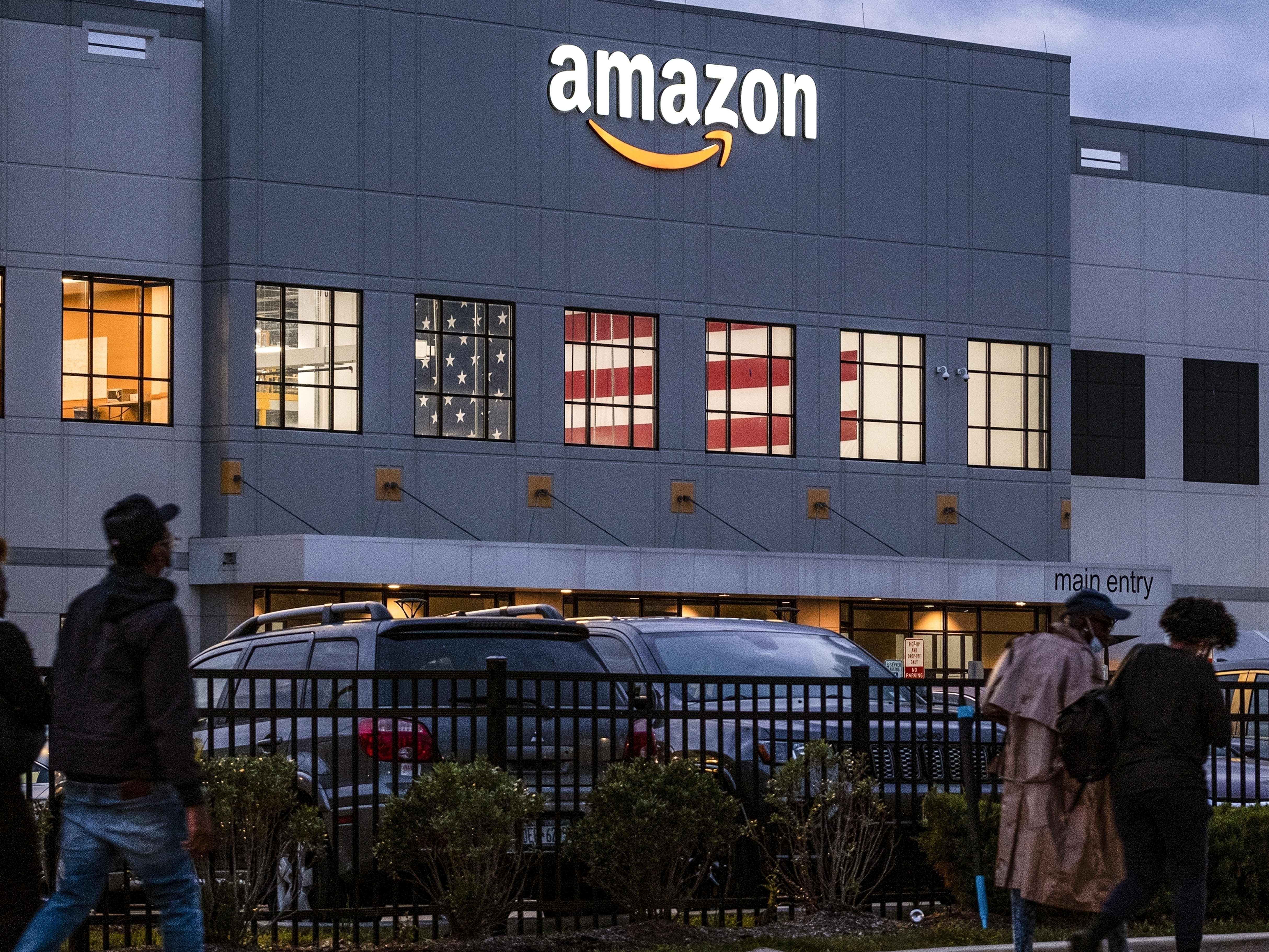 caption: People arrive for work at the Amazon distribution center at the New York City borough of Staten Island on Oct. 25, 2021.