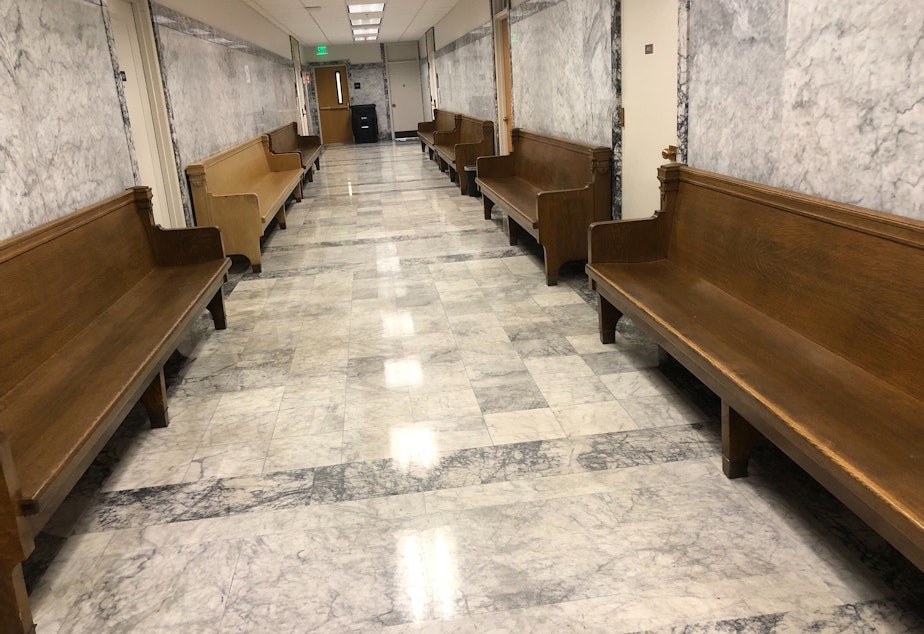 caption: Benches are stored in the corridors at the King County Courthouse to allow jurors to sit further apart in courtrooms in 2020. 
