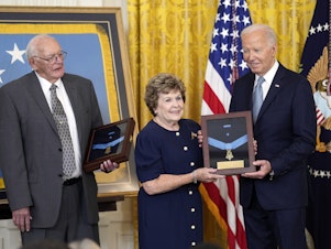 caption: President Biden presents the Medal of Honor to Theresa Chandler, the great-great-granddaughter of Pvt. George D. Wilson in the East Room at the White House in Washington, on Wednesday. The medals posthumously honor two U.S. Army privates who were part of a daring Union Army contingent that stole a Confederate train during the Civil War. U.S. Army Pvts. Philip G. Shadrach and George D. Wilson were captured by Confederates and executed by hanging. At left is Gerald Taylor, the great-great-nephew of Pvt. Phili