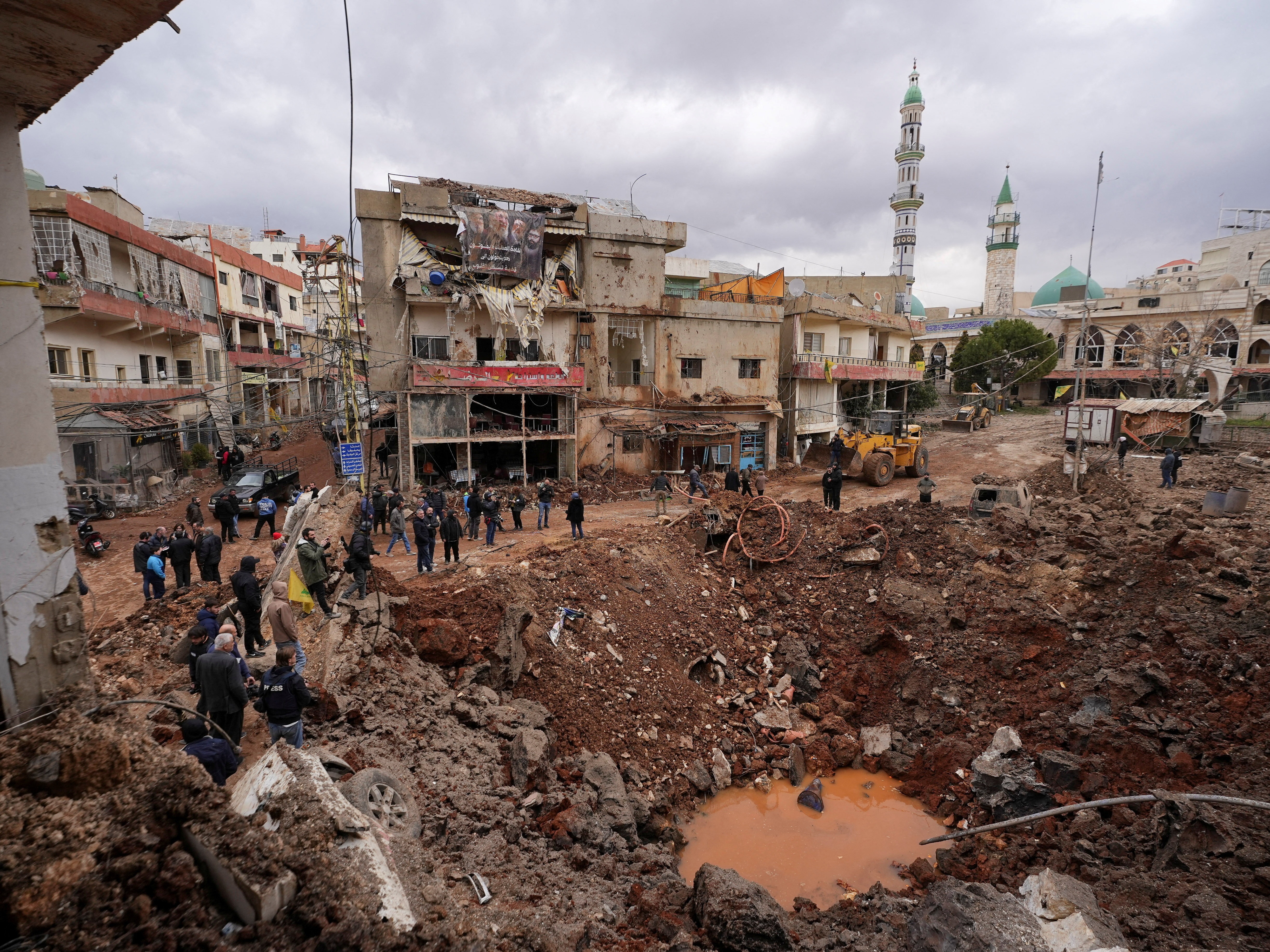 caption: March 7: People inspect the damage where Israel's military carried out an airborne operation that dropped troops overnight, in the town of Nabi Chit, Lebanon.
