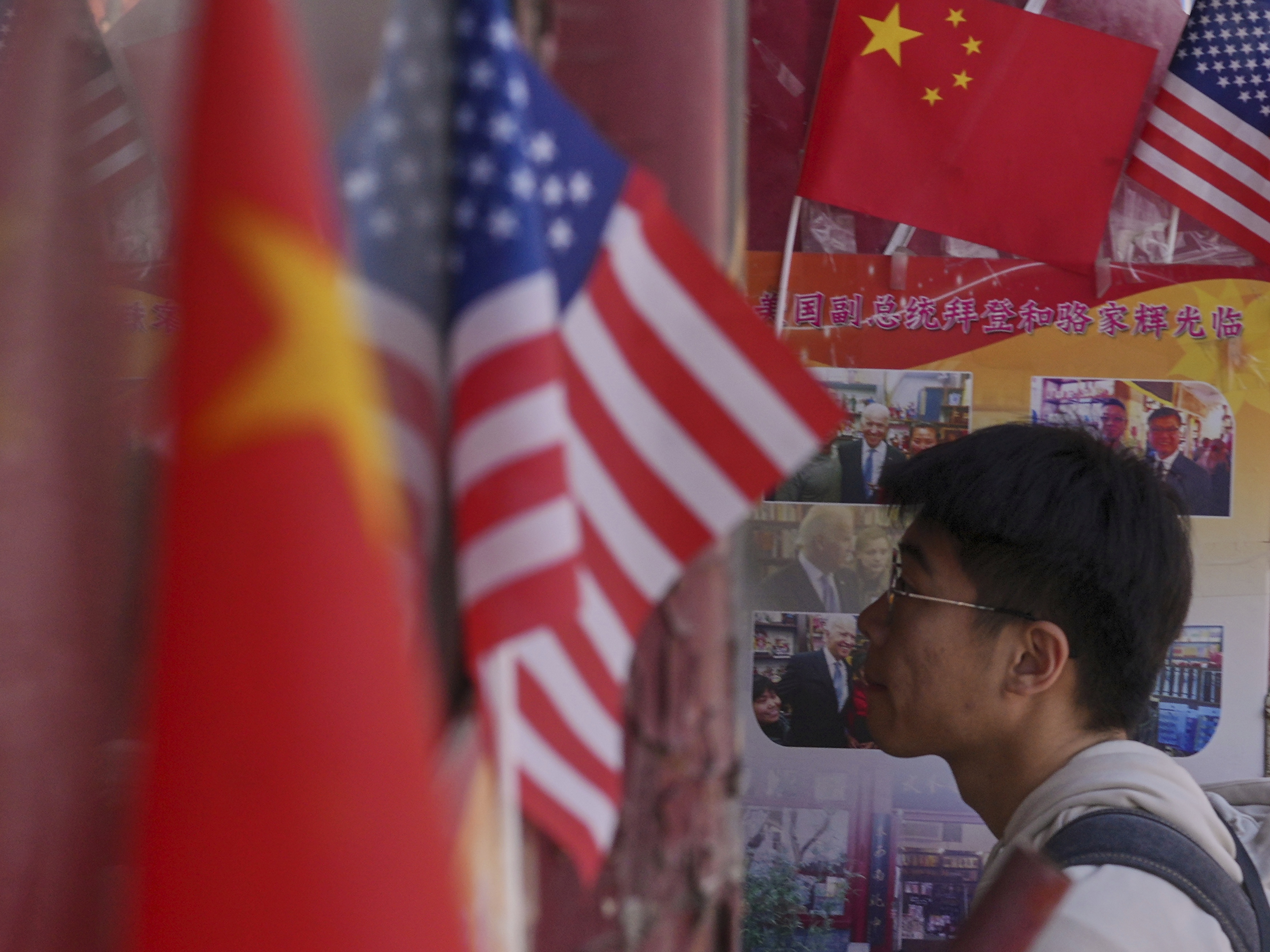 caption: A man walks into a store displaying Chinese and U.S. national flags in Beijing on Thursday.