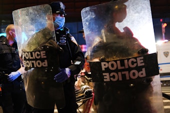 caption: Police confront protesters in front of the Barclays Center in Brooklyn, NY, on May 29, 2020.