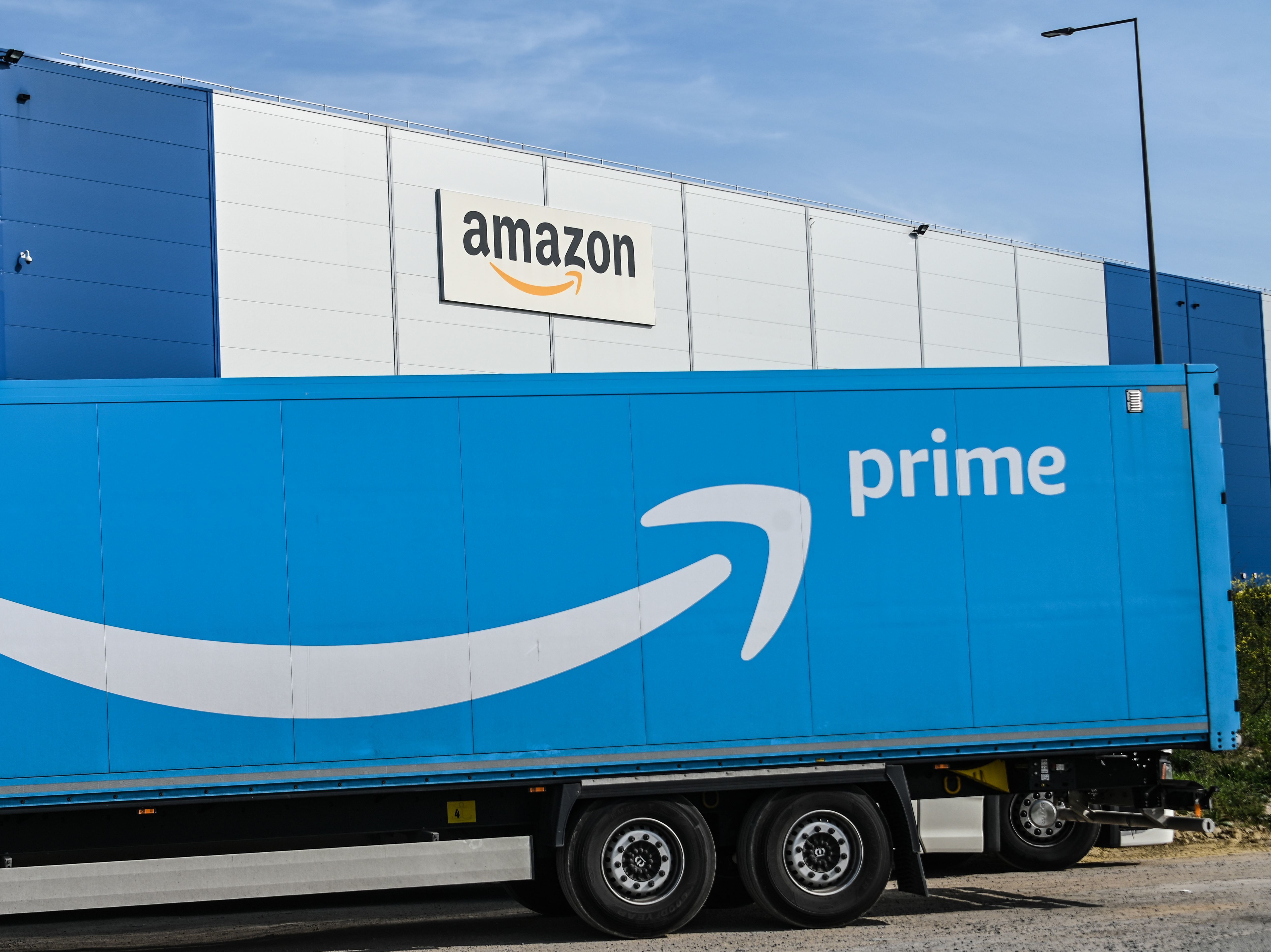 caption: An Amazon delivery truck is parked outside a warehouse in France on April 16. The online retail giant's revenues and profits soared in the second quarter.