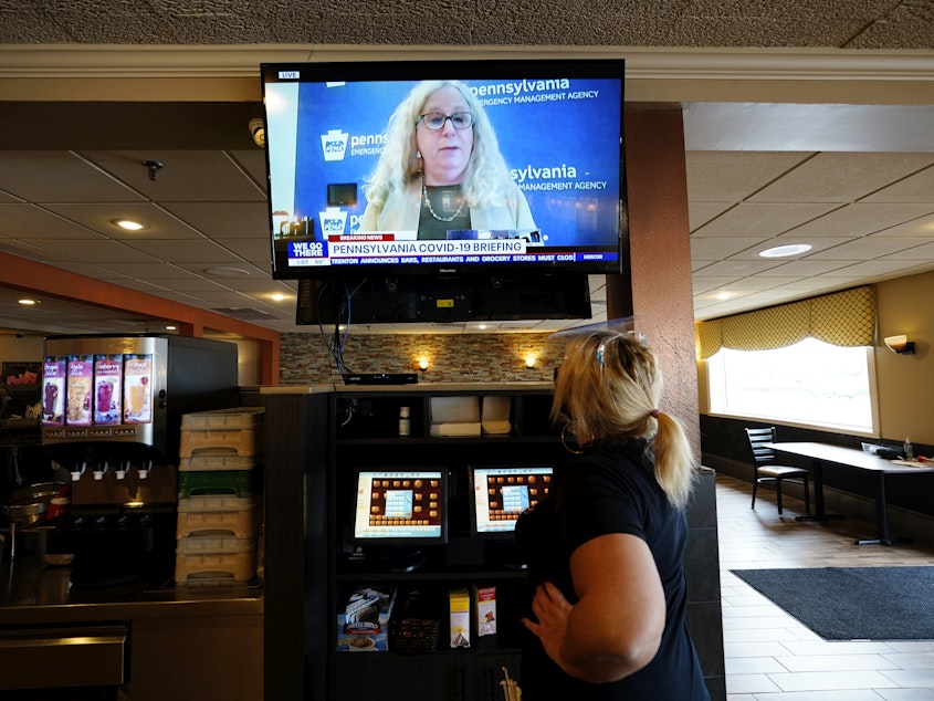 caption: A waitress in South Philadelphia watches a television briefing by Pennsylvania's health secretary, Dr. Rachel Levine, on Nov. 17. Levine says a COVID-19 vaccine is "the light at the end of the tunnel," but says it will be months before it's available to the general public.