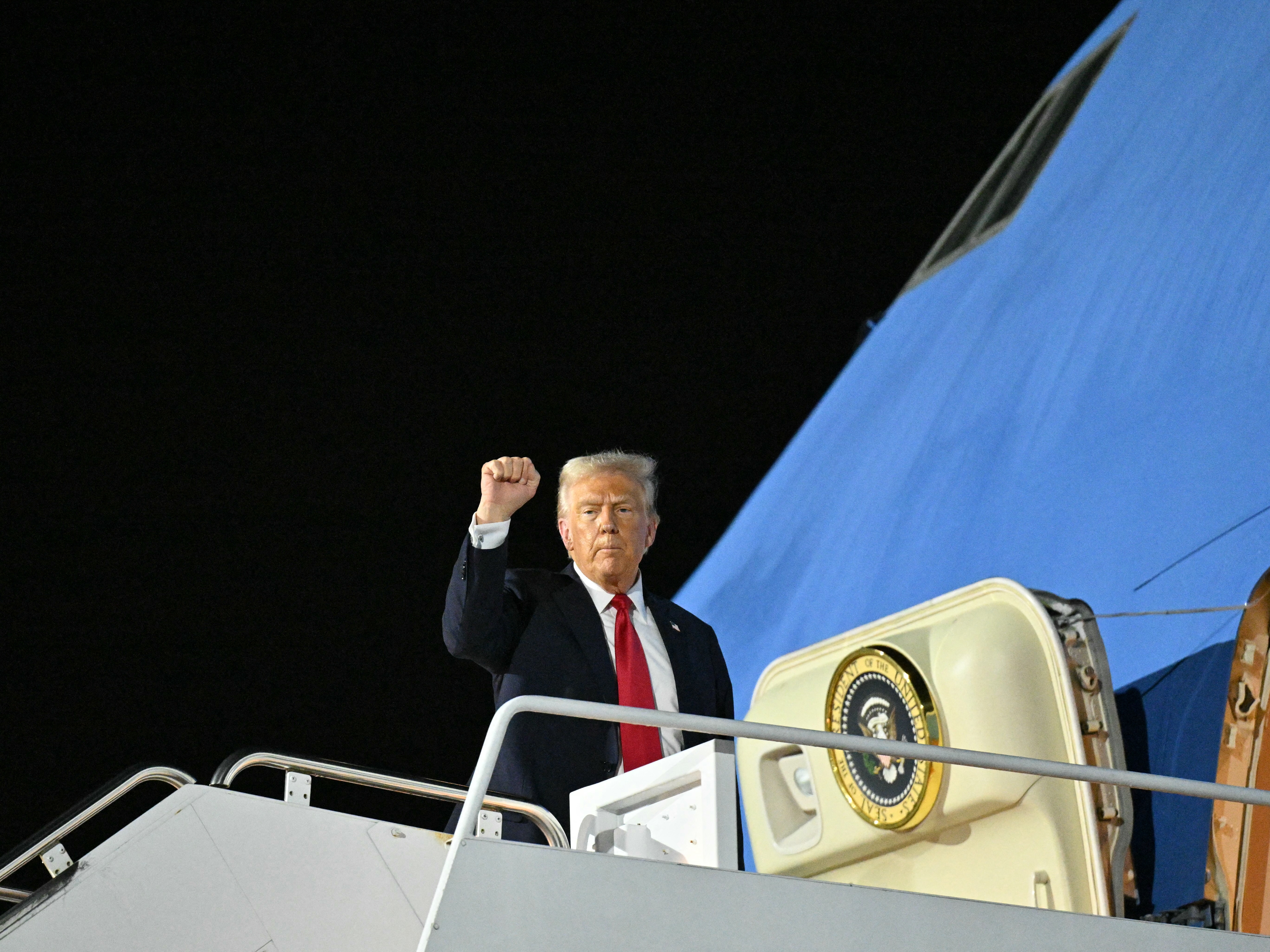 caption: President Trump boards Air Force One in Louisiana as he returns to Washington after attending Super Bowl LIX.