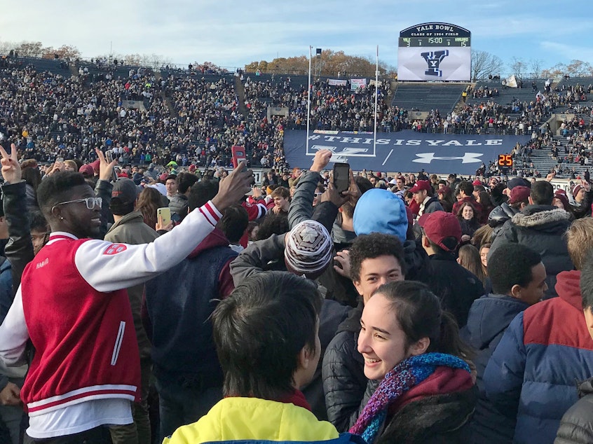 caption: Demonstrators stage a protest on the field at the Yale Bowl disrupting the start of the second half of an NCAA college football game between Harvard and Yale, Saturday in in New Haven, Conn.