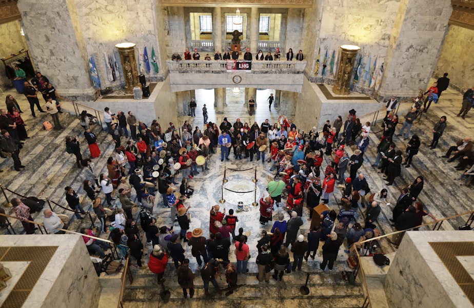caption: Native American tribal members and supporters form a drum circle around the Washington state seal and perform in the rotunda of the Capitol in Olympia, Wash. The gathering was part of Native American Indian Lobby Day and supported issues such as the Puyallup Tribe's protest against the construction of a liquified natural gas plant being built in Tacoma, Wash. by Puget Sound Energy, as well as the awareness of missing and murdered indigenous women in Washington state.