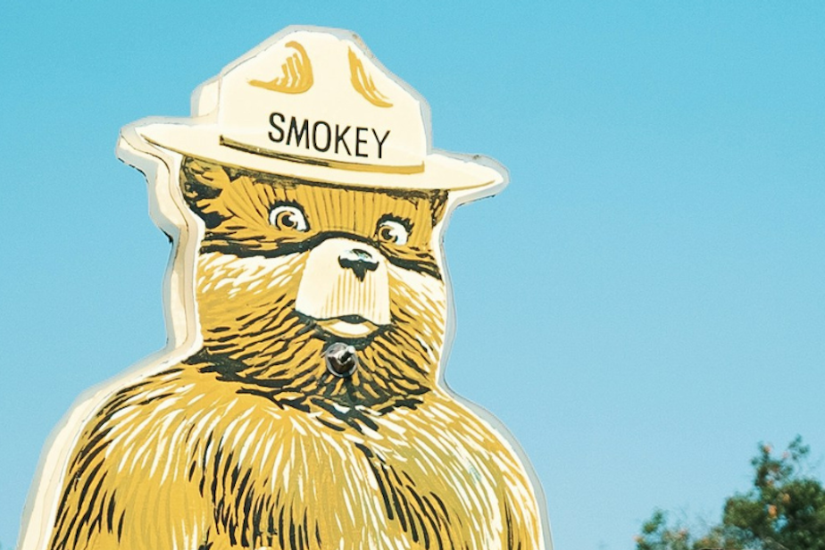 caption: Smokey the Bear on a sign noting the fire danger at a federal park. 