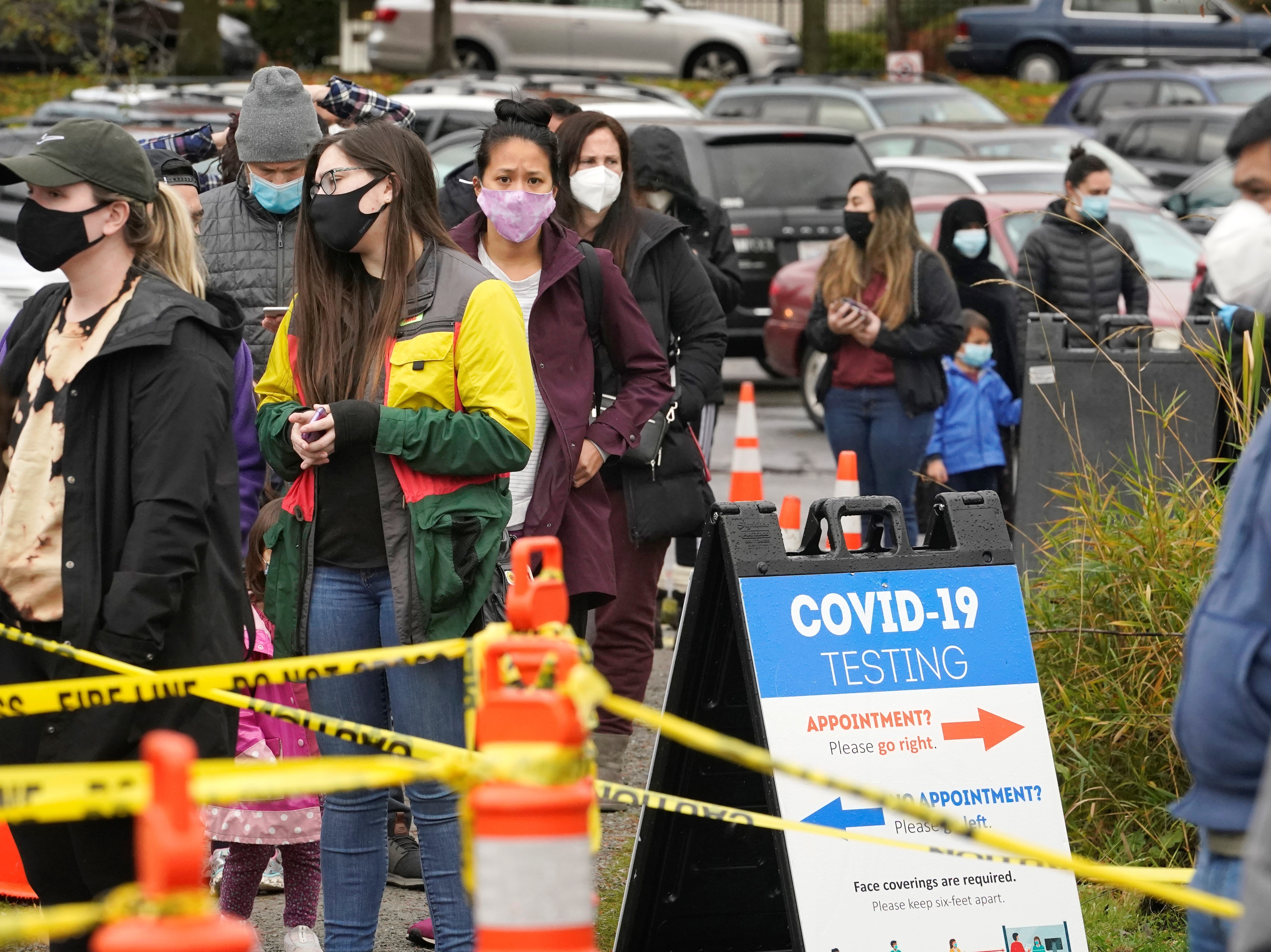 caption: People line up to be tested for the coronavirus at a free testing site Wednesday, Nov. 18 in Seattle.