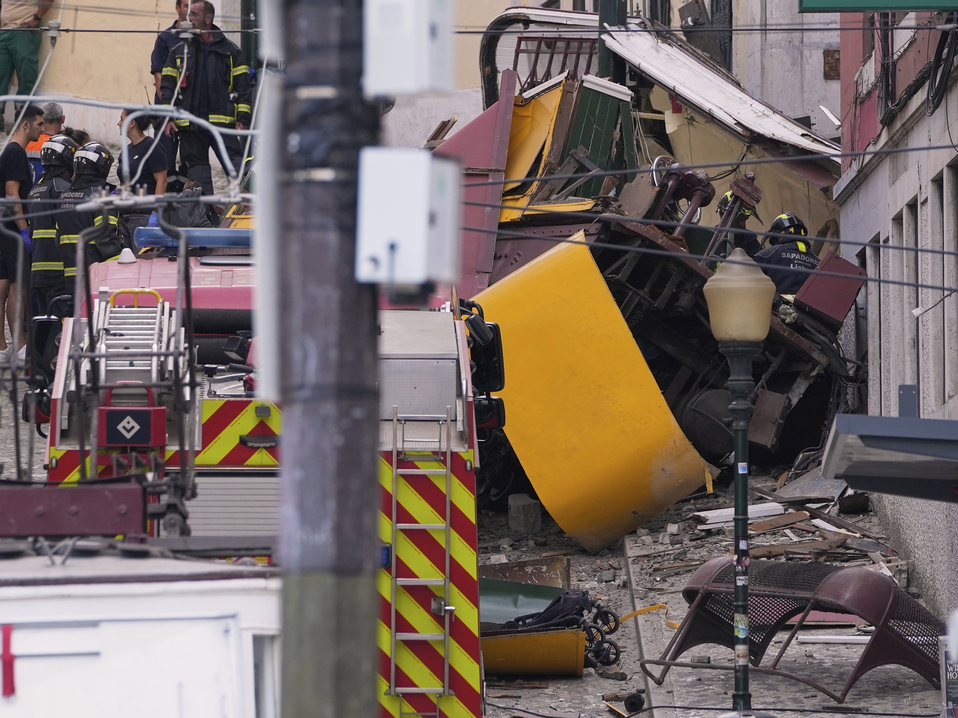 caption: Emergency teams work at the site of a derailed electric streetcar in Lisbon, Portugal on Wednesday.