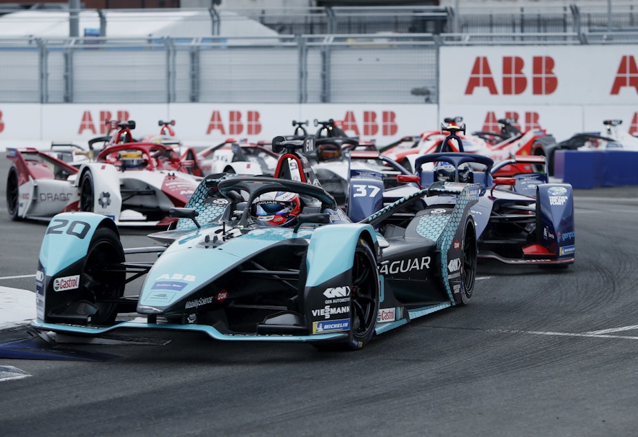 caption: Major automakers like Jaguar develop all-electric race cars to compete in Formula E. Here Mitch Evans, in a Jaguar, leads rivals during the ABB FIA Formula E Championship in New York City on July 11.