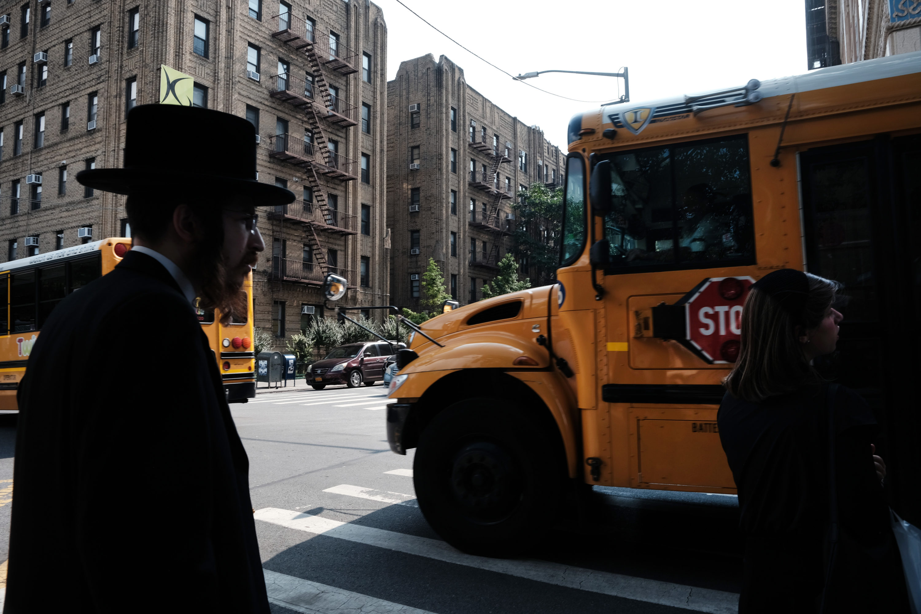 caption: A yeshiva school bus drives through Borough Park on Sept. 12, 2022 in the Brooklyn borough of New York City. (Spencer Platt/Getty Images)
