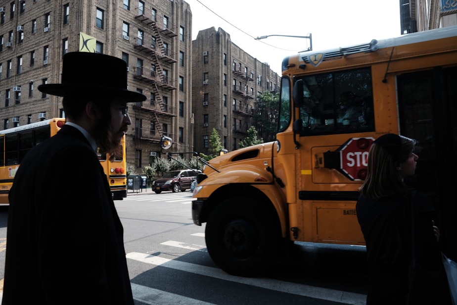 caption: A yeshiva school bus drives through Borough Park on Sept. 12, 2022 in the Brooklyn borough of New York City. (Spencer Platt/Getty Images)