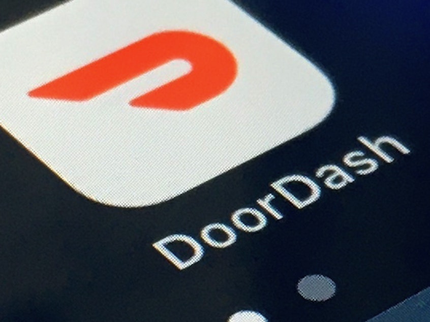 caption: In this Feb. 27, 2020, file photo, the DoorDash app is shown on a smartphone in New York. DoorDash is cutting more than 1,200 corporate jobs, saying it hired too many people when demand for its services increased during the COVID-19 pandemic.