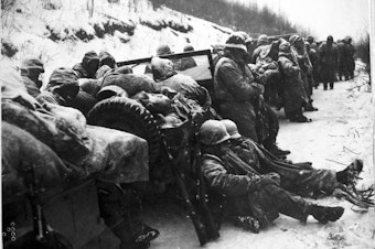 caption: Marines of the 5th and 7th regiments who hurled back a surprise onslaught by three Chinese communist divisions wait to withdraw from the Chosin Reservoir area circa December 1950.