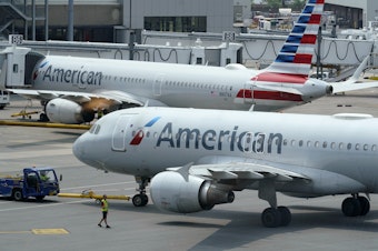 caption: American Airlines passenger jets prepare for departure at Boston Logan International Airport in July. American is one of six airlines the Pentagon is turning to for assistance with the Afghan evacuation effort.